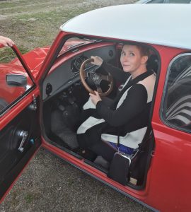 Hannele istuu punaisessa autossa
