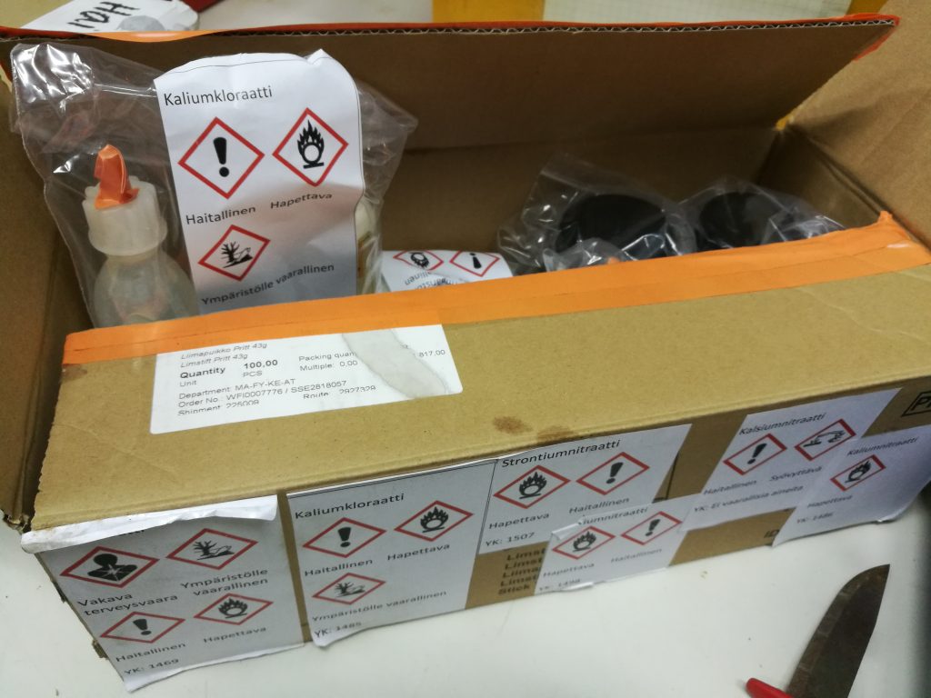 Pahvilaatikko johon pakattu kemikaaleja, merkitty ulkopuolelle mitä kemikaaleja