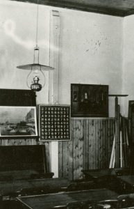 mustavalkoinen valokuva luokkahuoneesta, taustalla kertaustaulukko